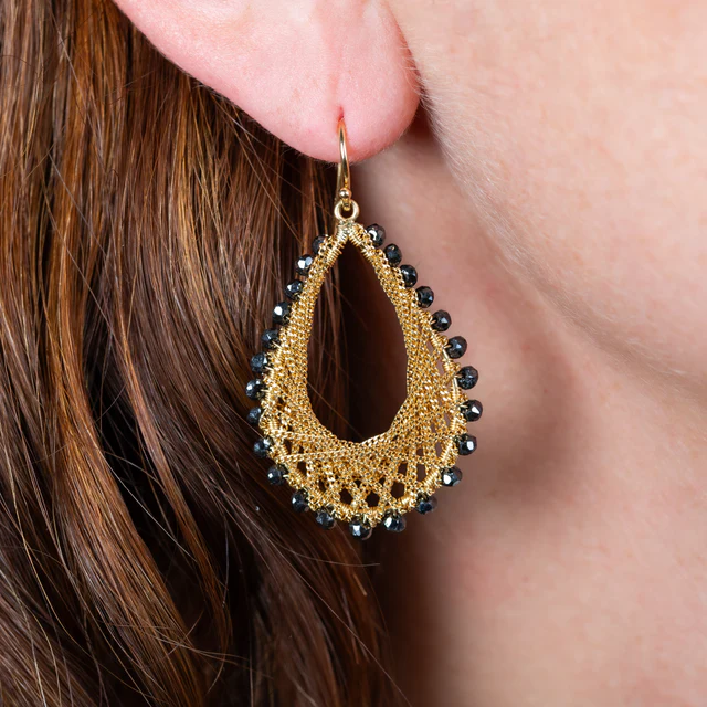 Teardrop earrings featuring woven 18k yellow gold chain accented with black diamonds on a French hook.