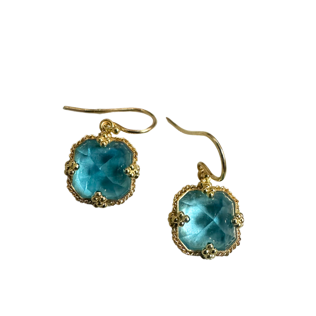 Inverted square blue topaz earrings set in 18k yellow gold with decorative beaded prongs and hook backings.