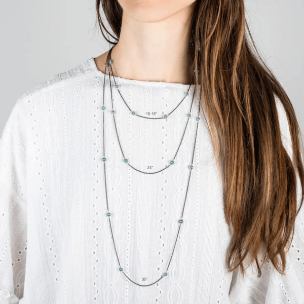 Amali blue topaz station necklace in oxidized silver and 18k gold, shown in 16-18, 24, and 36-inch lengths on a model.
