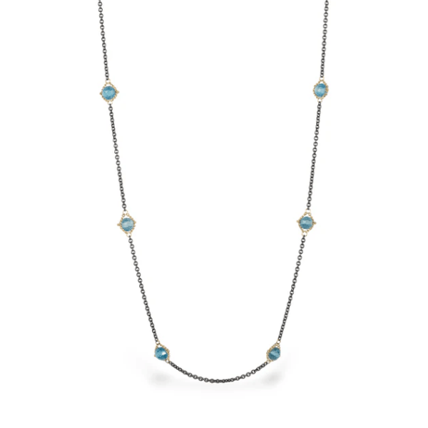 Amali station necklace featuring blue topaz stones set in 18k yellow gold on an oxidized sterling silver chain.