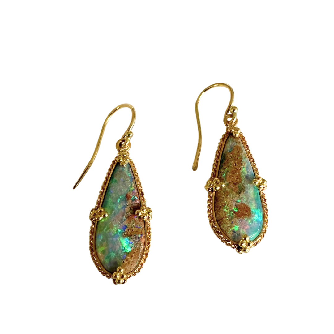 Pear-shaped boulder opal drop earrings set in 18k yellow gold with intricate rope-style detailing.