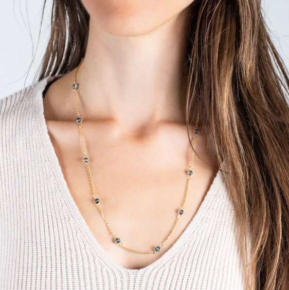 Deluxe Whisper necklace featuring London Blue Topaz stones hand-woven into an 18k yellow gold chain.