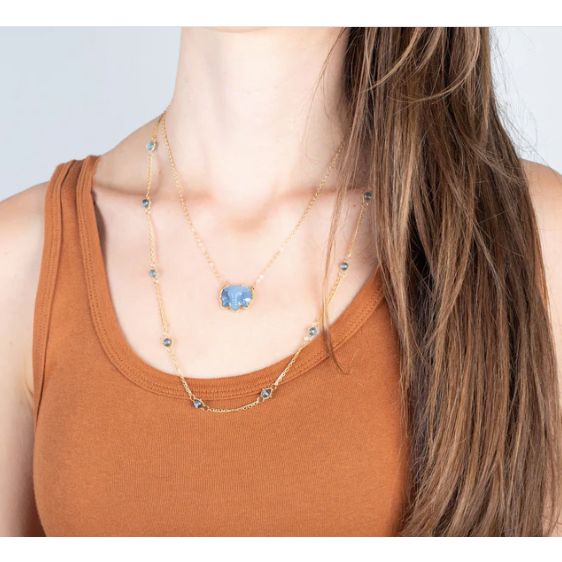 18k yellow gold necklace featuring London Blue Topaz stones woven into a delicate chain worn on a model.
