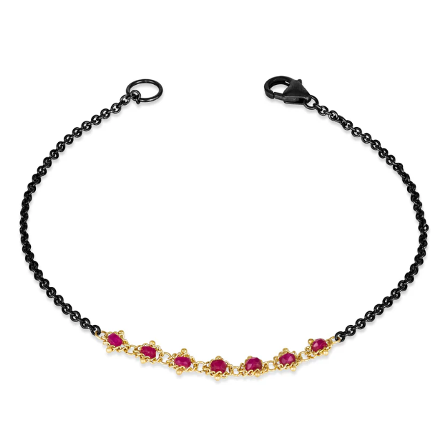 Oxidized sterling silver bracelet featuring seven faceted ruby beads woven into an 18k yellow gold textile chain.