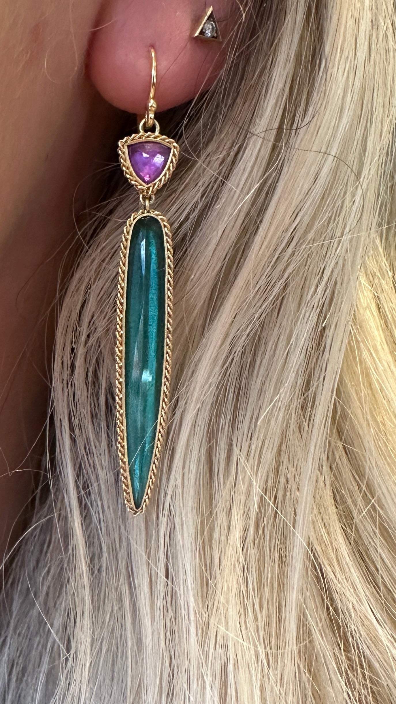 18k yellow gold drop earrings featuring a purple sapphire stud and a long, slender green tourmaline in a rope-textured setting.