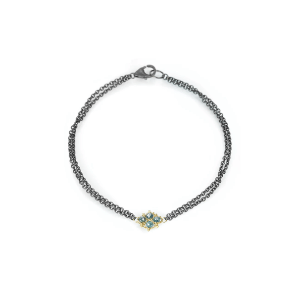 Oxidized silver double chain bracelet with a woven 18k gold centerpiece featuring sparkling blue diamonds.