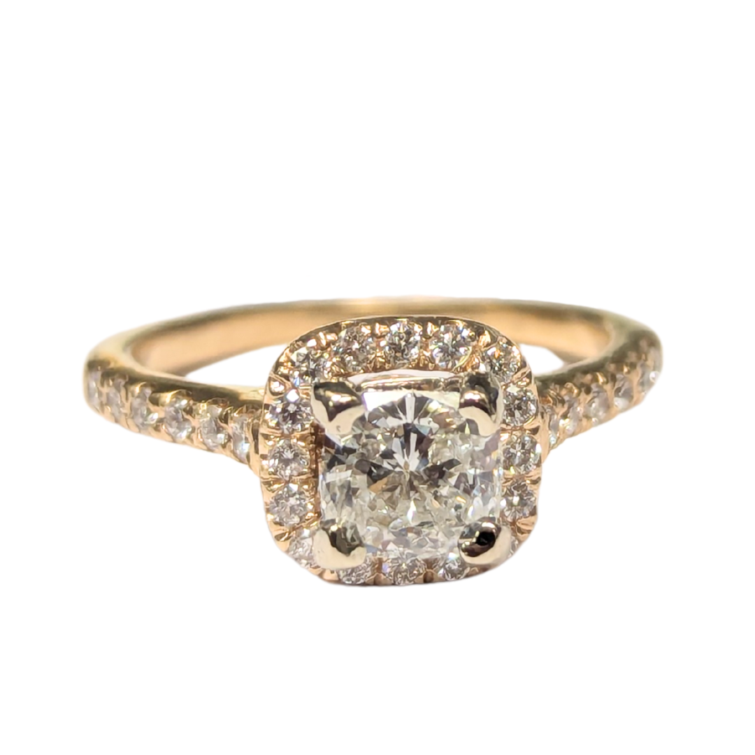 10k yellow gold engagement ring with a 0.69ct cushion cut diamond and a sparkling round diamond halo setting.