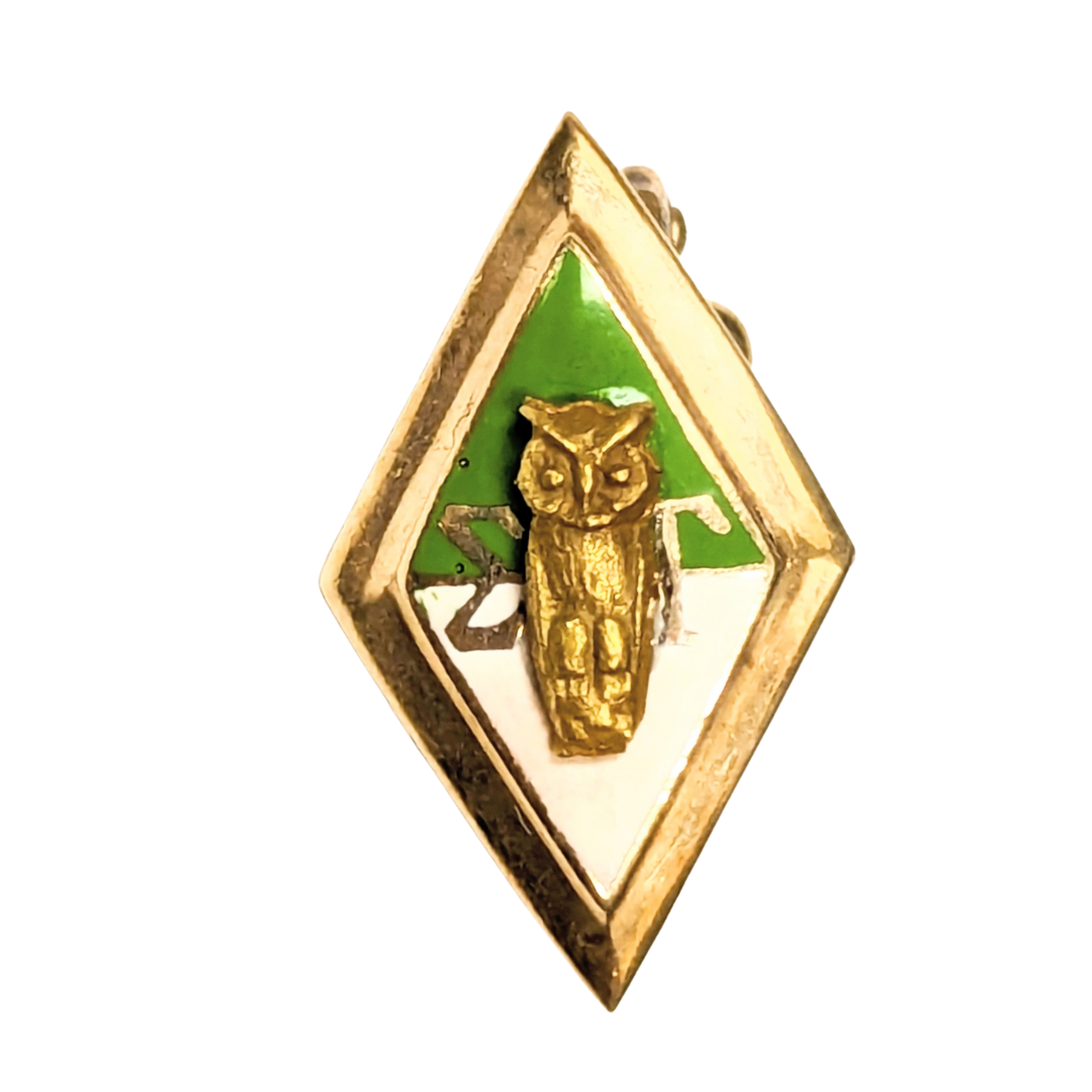 10k yellow gold diamond-shaped charm featuring a sculpted owl over green and white enamel with Greek letters.