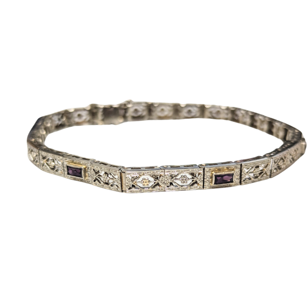 14k white gold Art Deco filigree bracelet featuring forget-me-not floral motifs and baguette-cut purple amethysts.