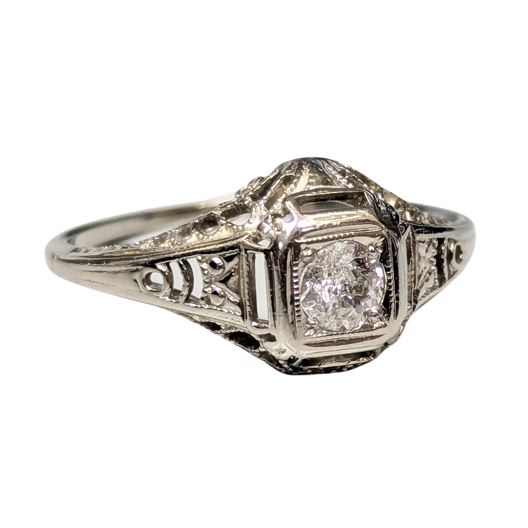 14k white gold Art Deco filigree ring featuring a 0.18 carat Old European cut diamond.