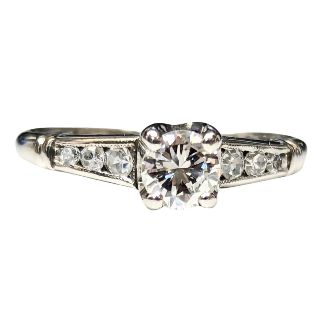 14k white gold engagement ring featuring a round brilliant center diamond and six side accent diamonds.