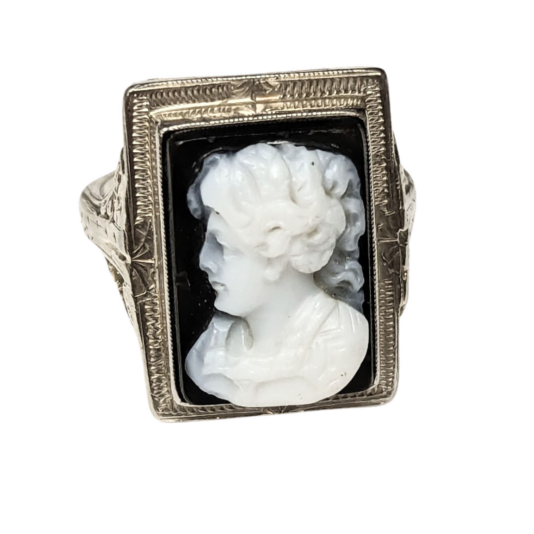 14k white gold ring featuring a rectangular black and white onyx cameo with intricate filigree metalwork.