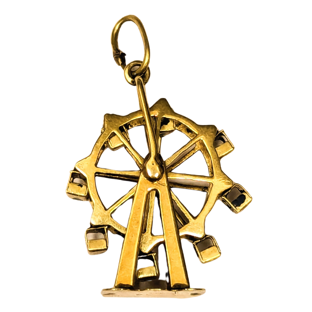 Vintage 14k yellow gold articulating Ferris wheel charm with a detailed spinning wheel design and attached jump ring.