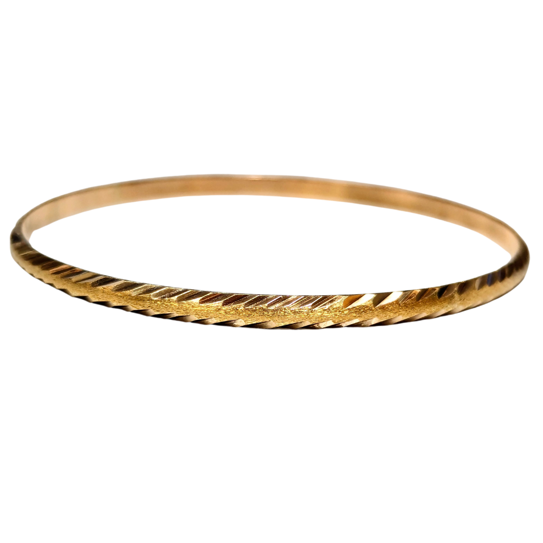 14k yellow gold bangle featuring a detailed bright cut x-pattern texture, handcrafted in Greece.