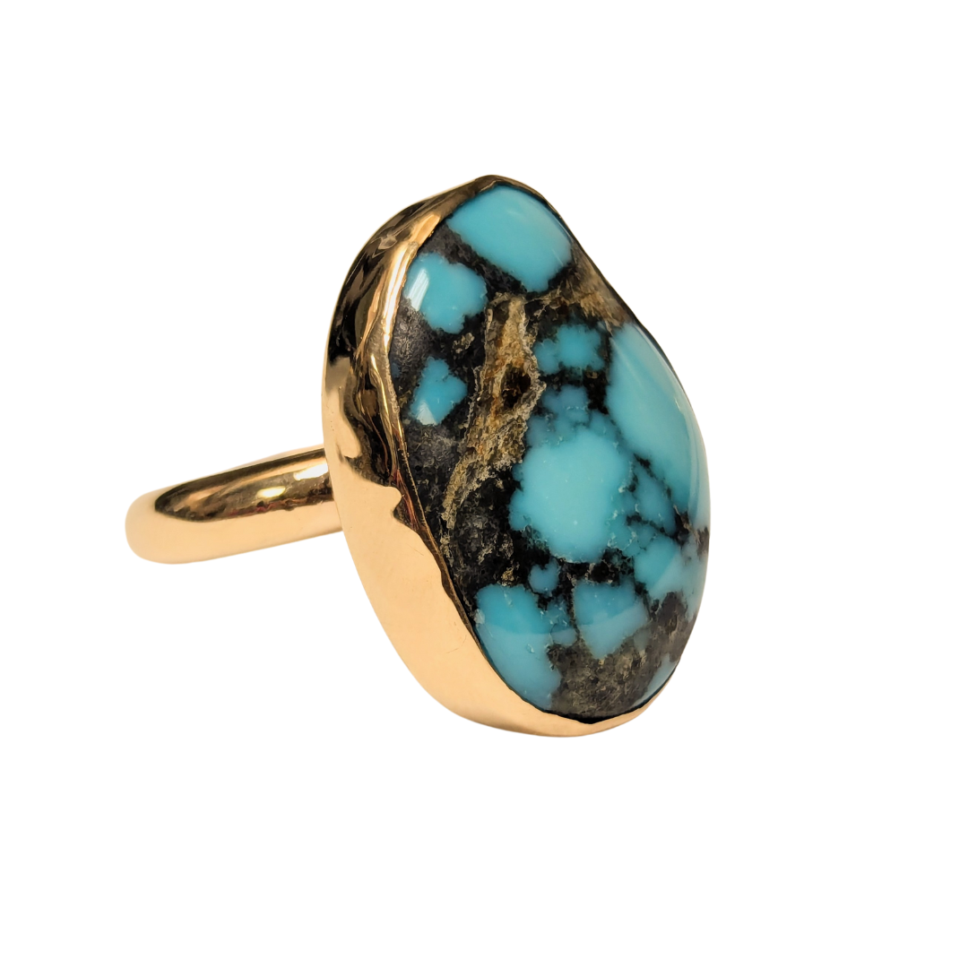 14k yellow gold ring featuring a large, bezel-set turquoise cabochon with natural dark matrix patterns.