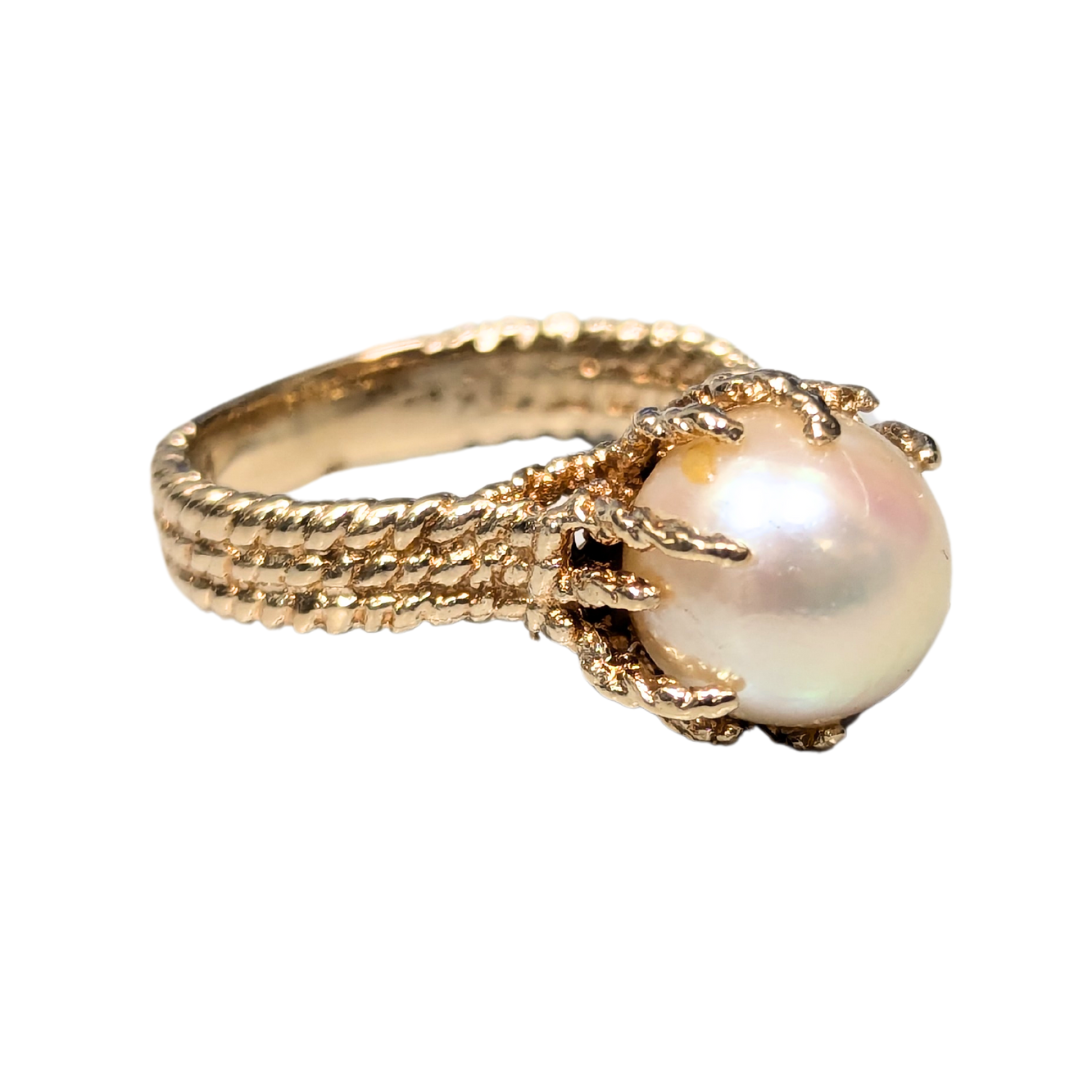 14k yellow gold brutalist ring featuring a 9mm cultured pearl set in textured rope-style metalwork.