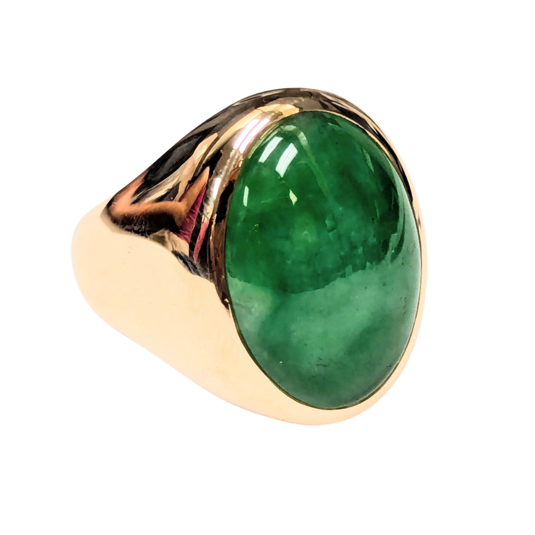 14k yellow gold ring featuring a large, polished green jade cabochon stone in a smooth, classic setting.