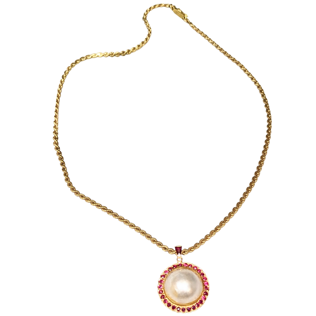 14k yellow gold mabe pearl pendant with ruby halo and diamond accent on an 18-inch S-link chain.