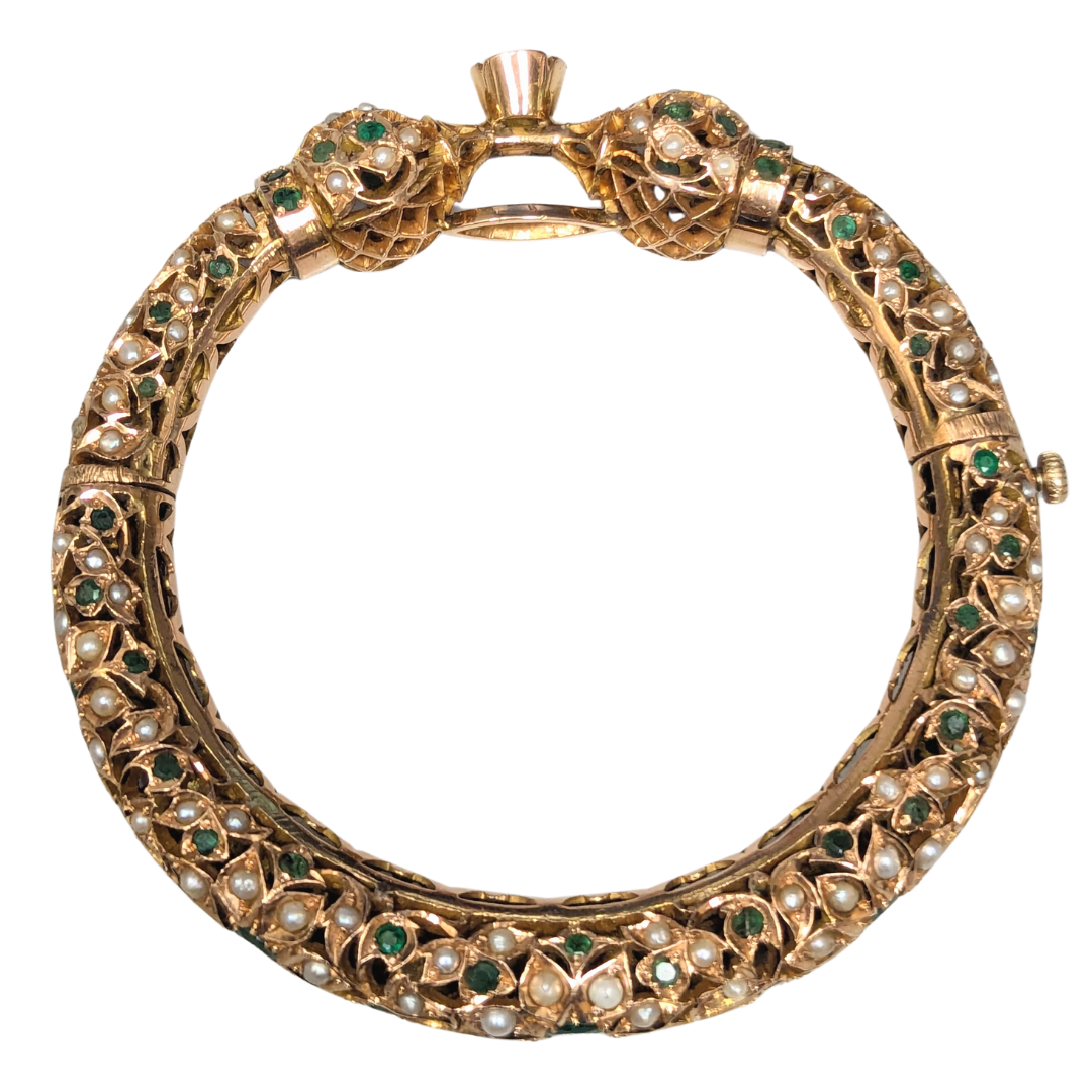 14k yellow gold Mughal bangle with pierced leaf motif, seed pearls, and round emeralds, 3-inch diameter.