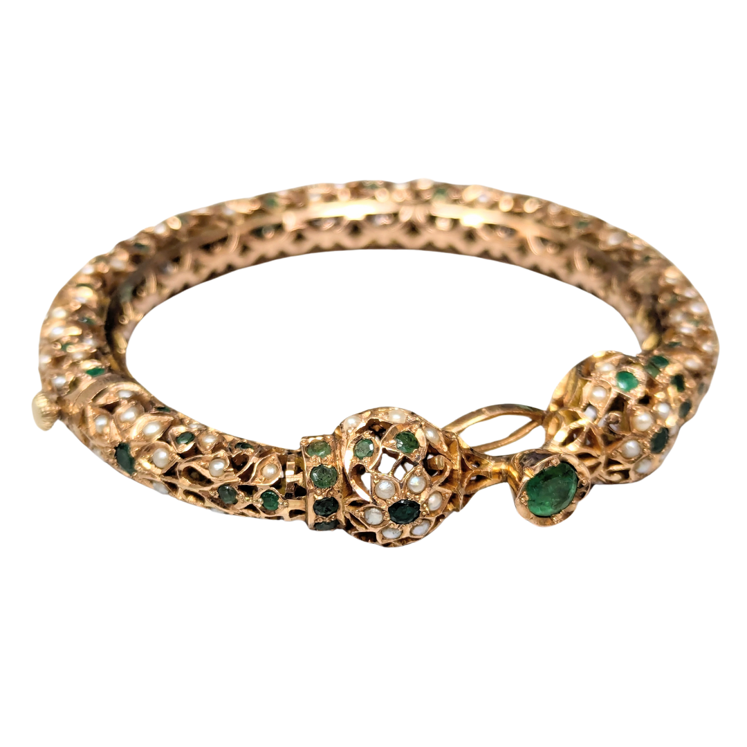 14k yellow gold Mughal bangle with pierced leaf motif, seed pearls, and round emeralds, 3-inch diameter.