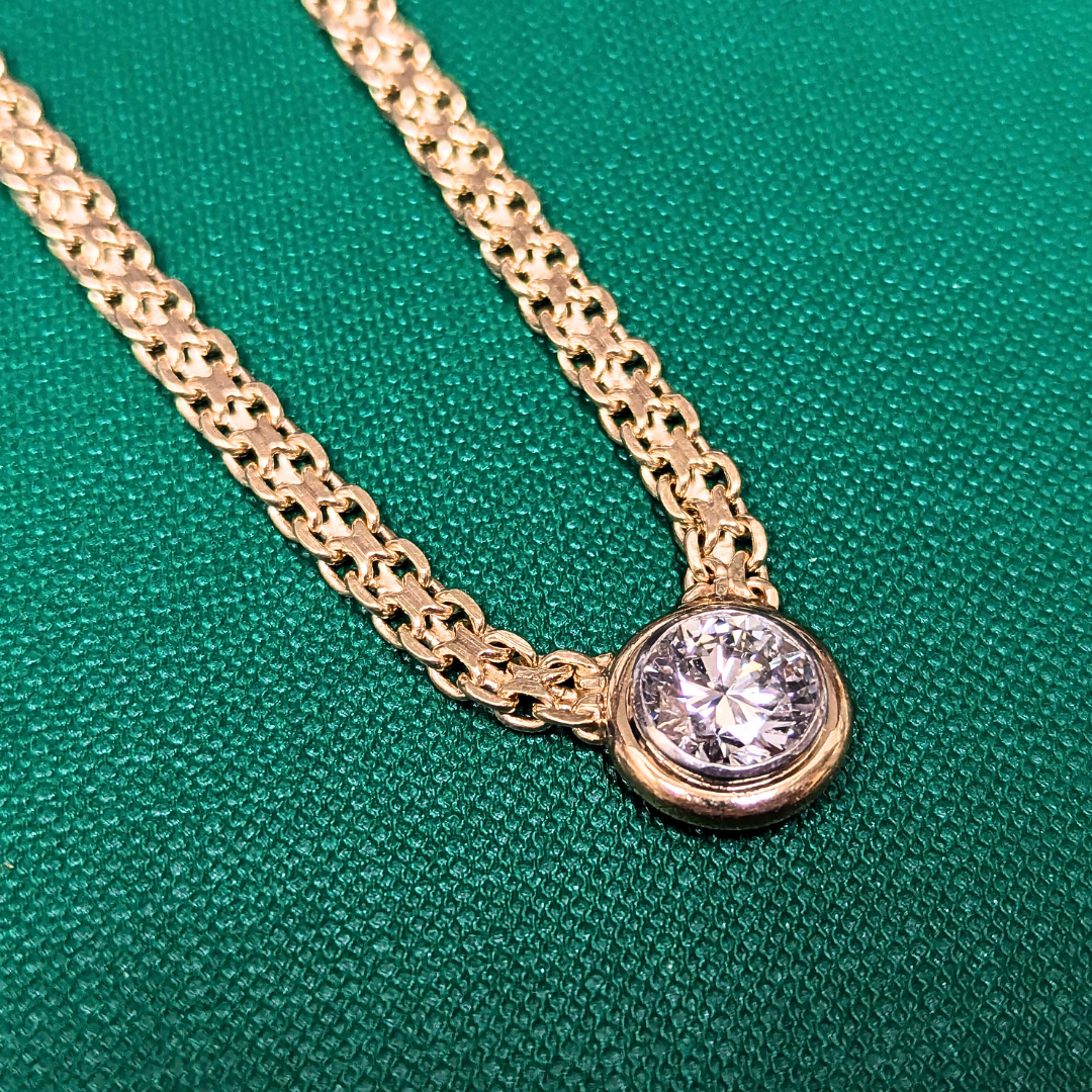 2.31 carat round brilliant diamond in a 14k yellow gold bezel setting on a woven X-link chain.