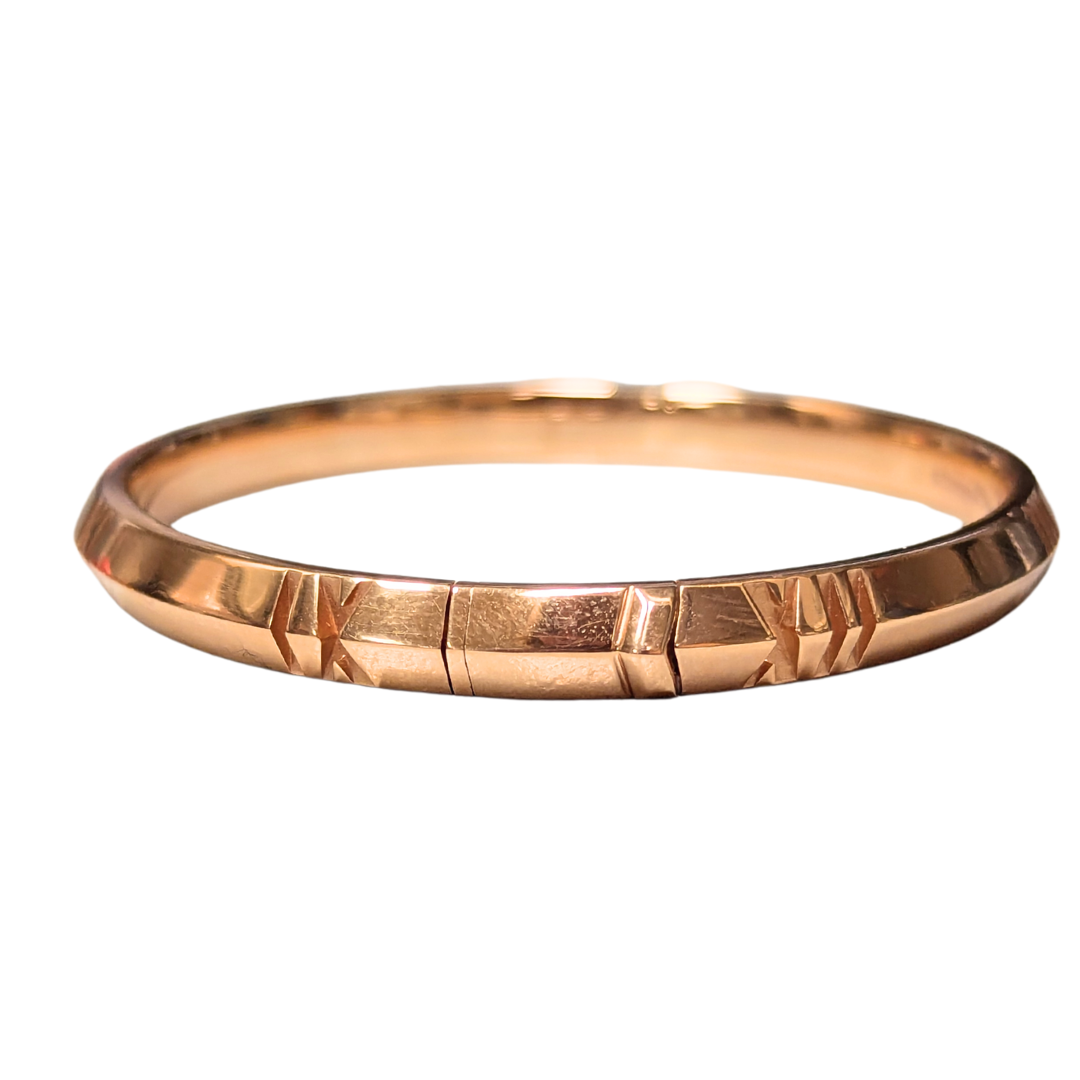 Tiffany & Co. Atlas bangle in 18k rose gold featuring engraved Roman numeral details, 6.5-inch length.