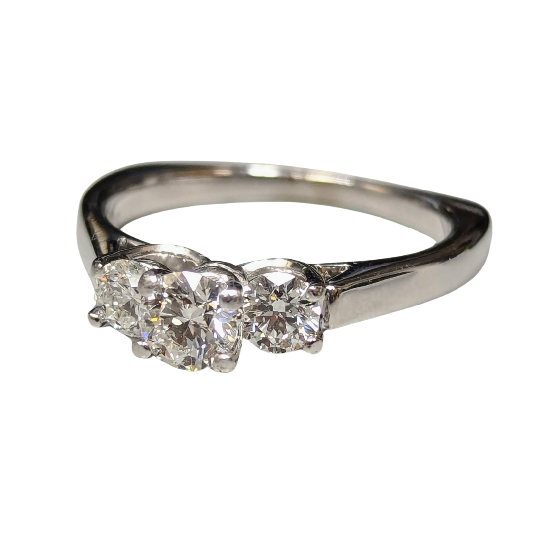 18k white gold three-stone engagement ring featuring a round brilliant cut diamond center and two side diamonds.