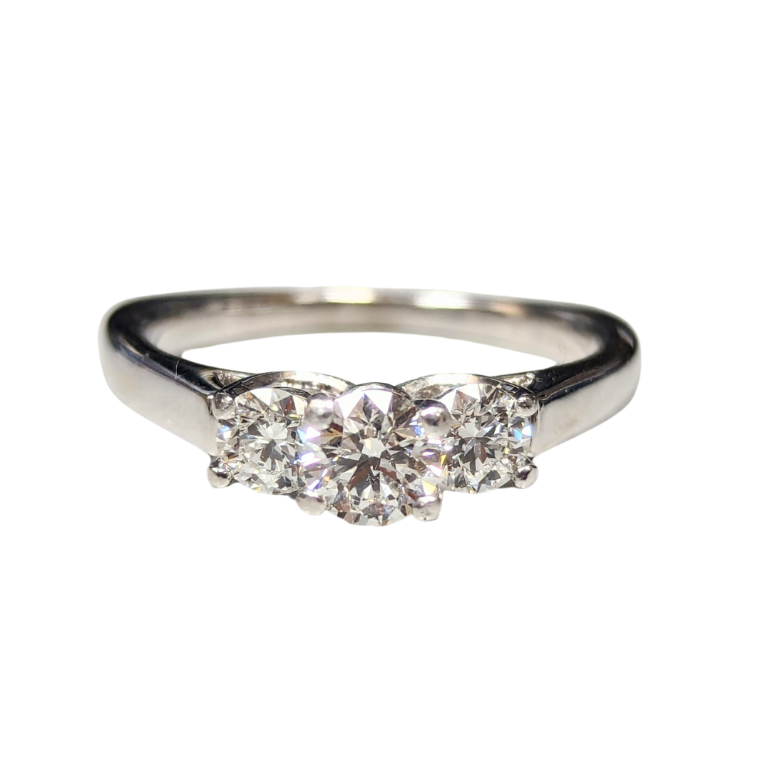 18k white gold three-stone engagement ring featuring a round brilliant cut center diamond and two side diamonds.