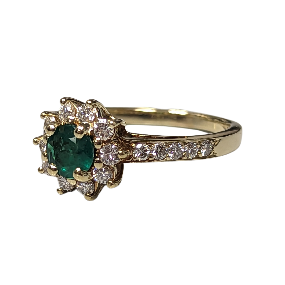 18k yellow gold ring featuring a round emerald center stone surrounded by a halo of brilliant-cut diamonds.