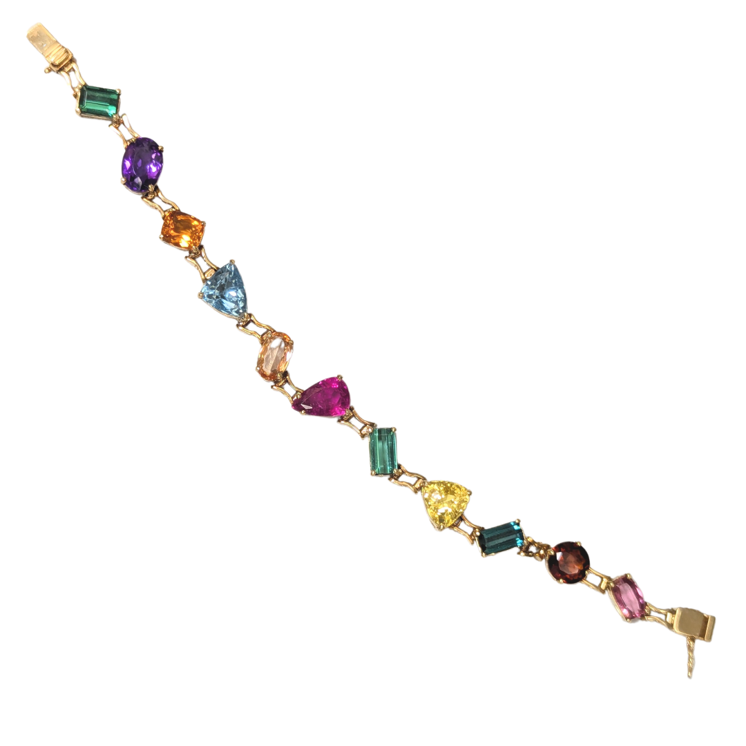 18k yellow gold line bracelet featuring a vibrant array of multi-cut, multi-colored natural gemstones.