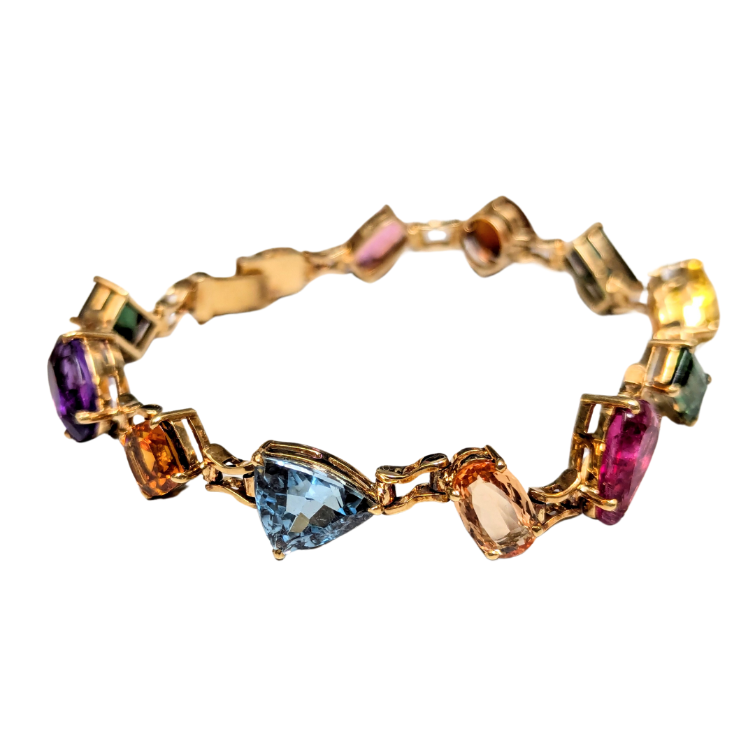 18k yellow gold line bracelet featuring a vibrant array of multi-cut, multi-colored natural gemstones.