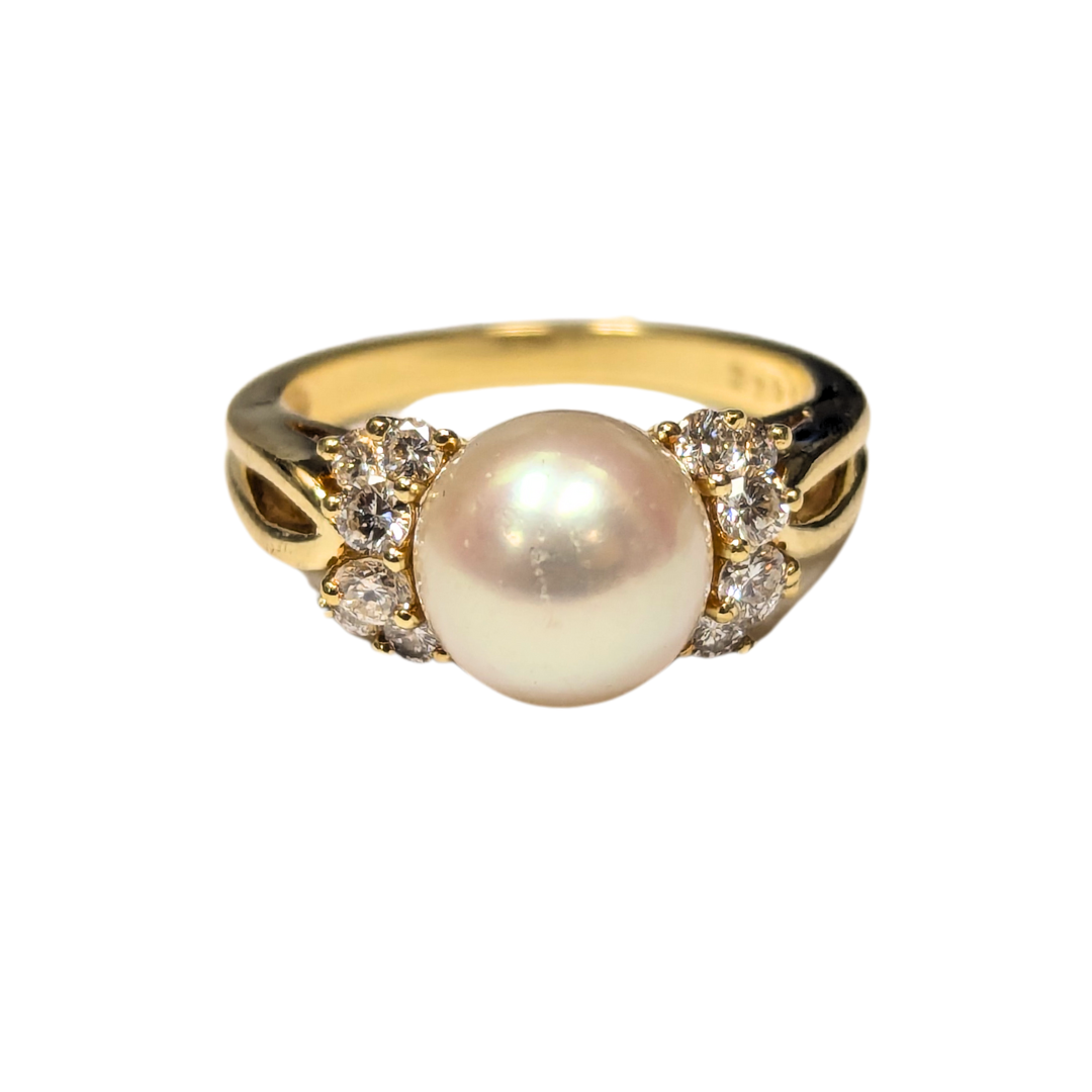 18k yellow gold ring with a central 8.65mm cultured pearl flanked by twelve sparkling round brilliant diamonds.