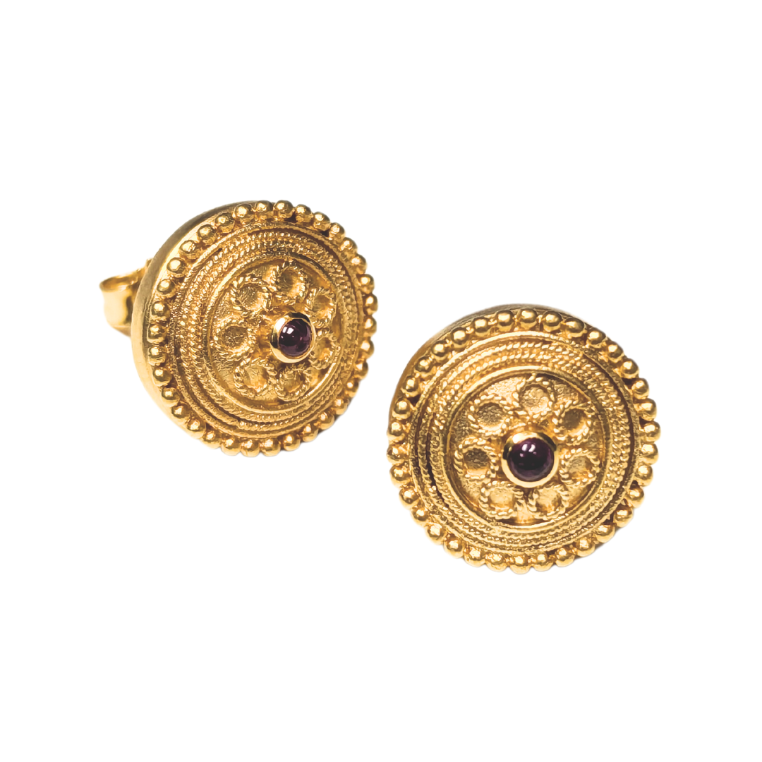 22k yellow gold Byzantine stud earrings featuring intricate circular patterns and a central cabochon ruby.