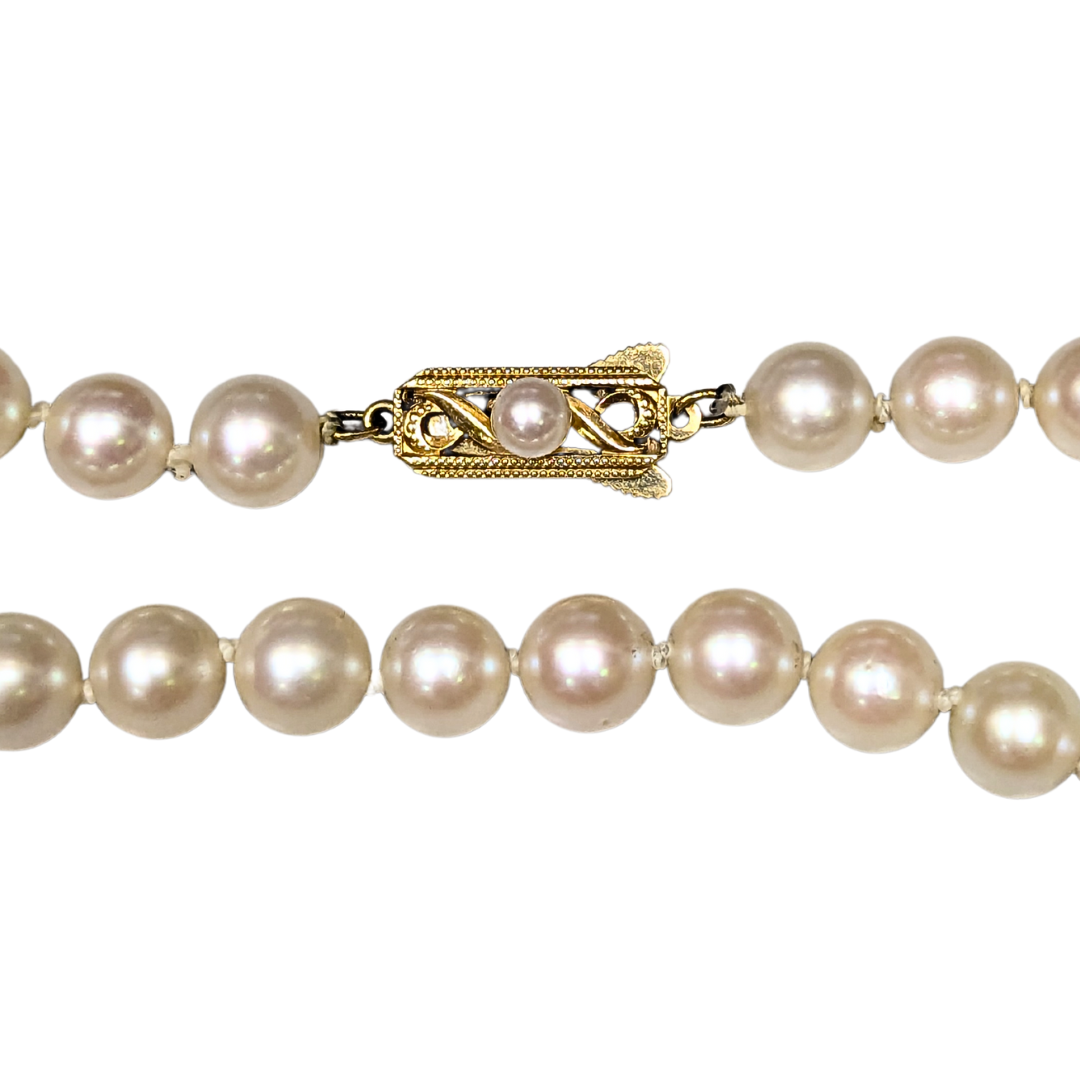 24-inch Mikimoto pearl strand featuring 7-7.5mm lustrous white pearls and an ornate 18k yellow gold filigree clasp.