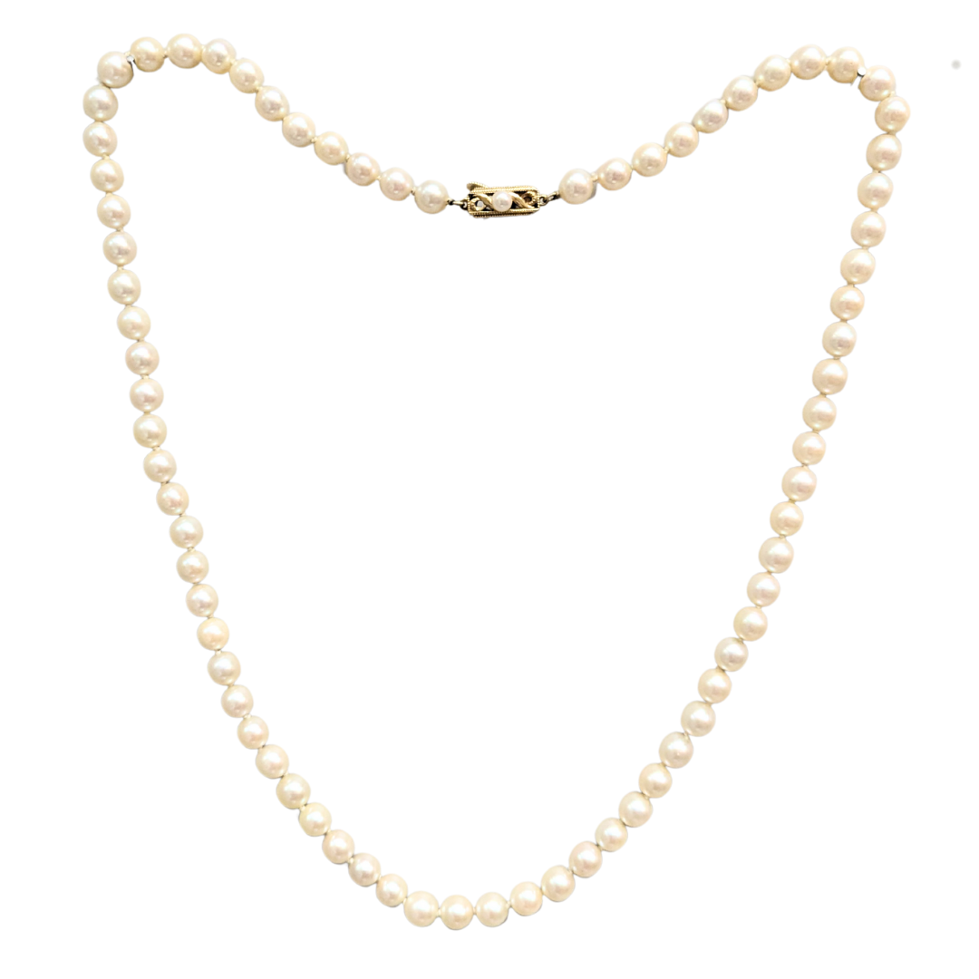 24-inch Mikimoto pearl necklace with 7-7.5mm white pearls and an ornate 18k yellow gold clasp.