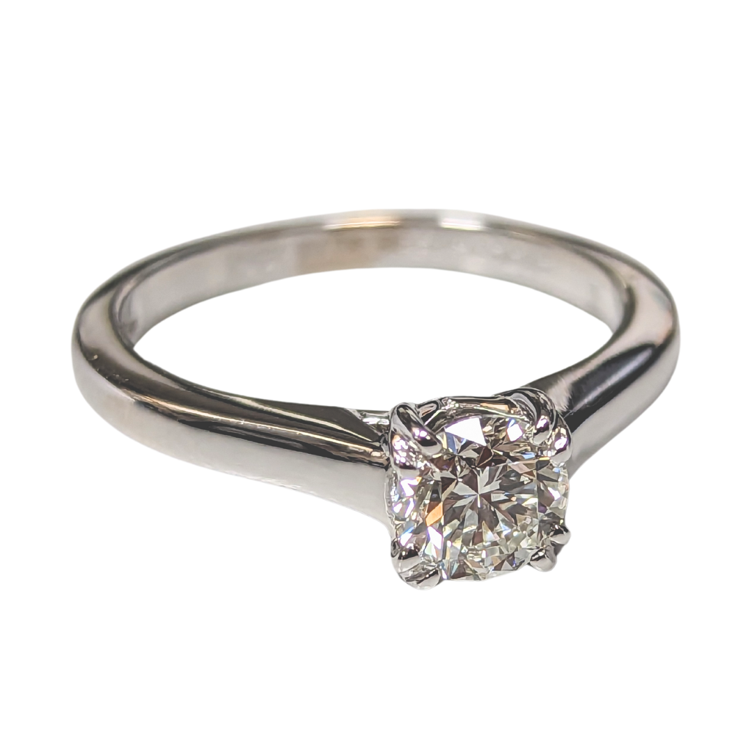 De Beers 18K white gold solitaire ring featuring a .70ct round brilliant cut diamond in a classic four-prong setting.