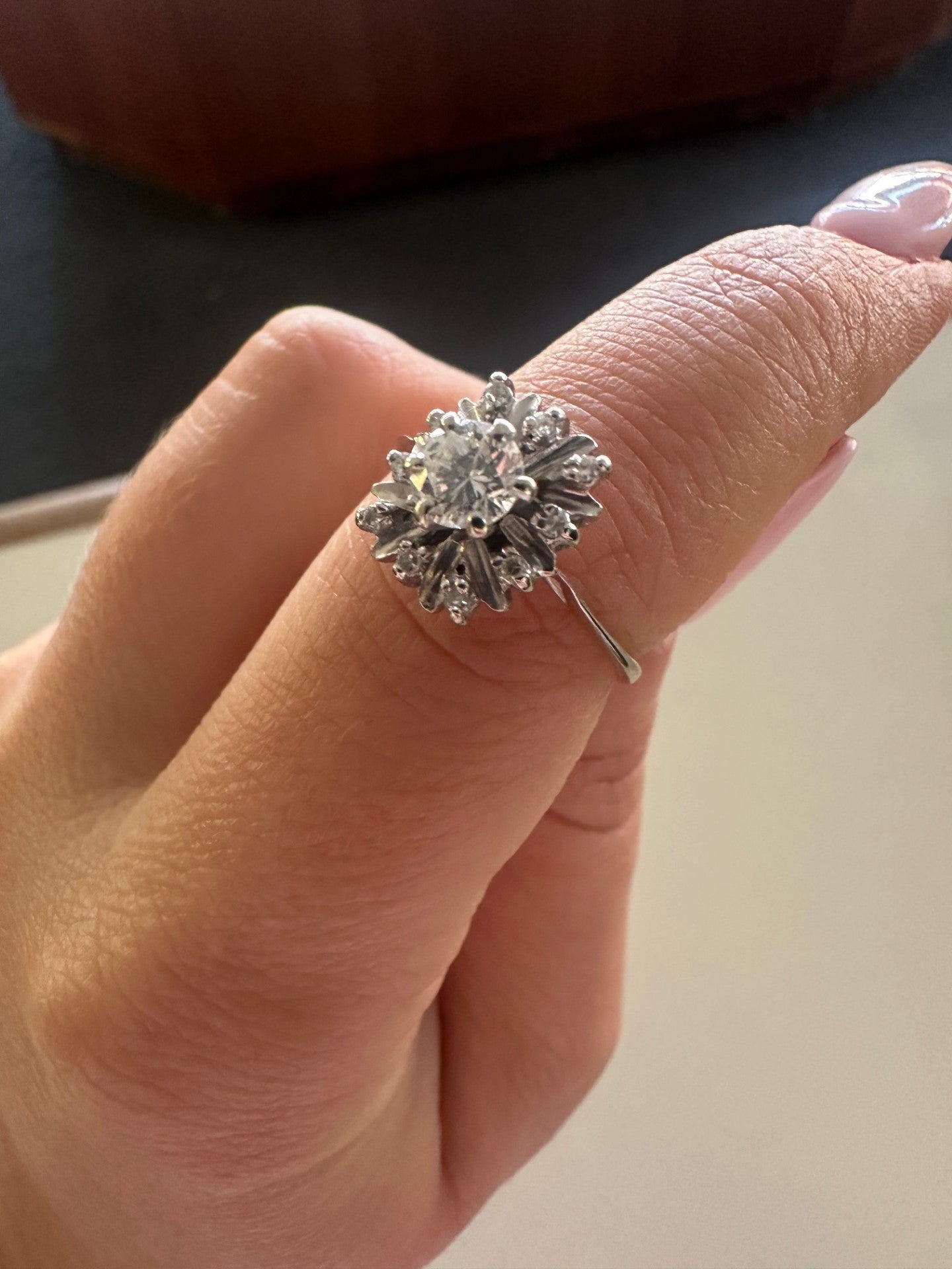 14k white gold ballerina ring with a 0.45ct round brilliant center diamond and accent stones on a finger.