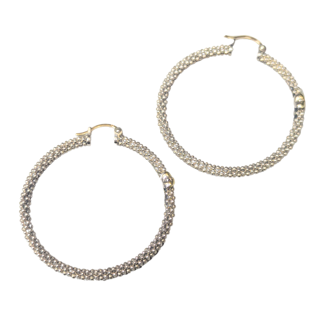 Lagos 1.5-inch hoop earrings in textured sterling silver with 18k yellow gold latch closures.