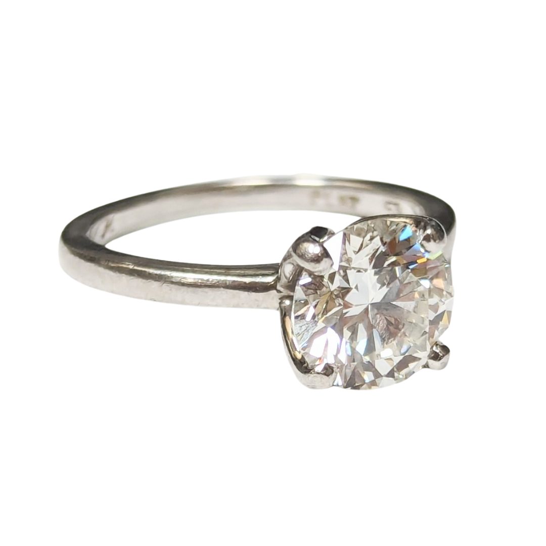 Monique Lhuillier platinum solitaire ring with a 2.10 carat round brilliant cut diamond on a white background.