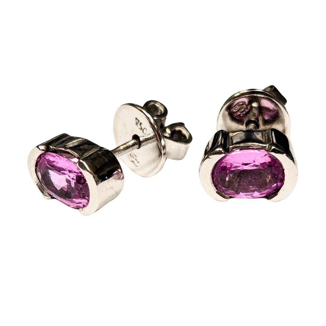 18k white gold stud earrings featuring 2.00ct oval pink sapphires in a modern half-bezel setting.