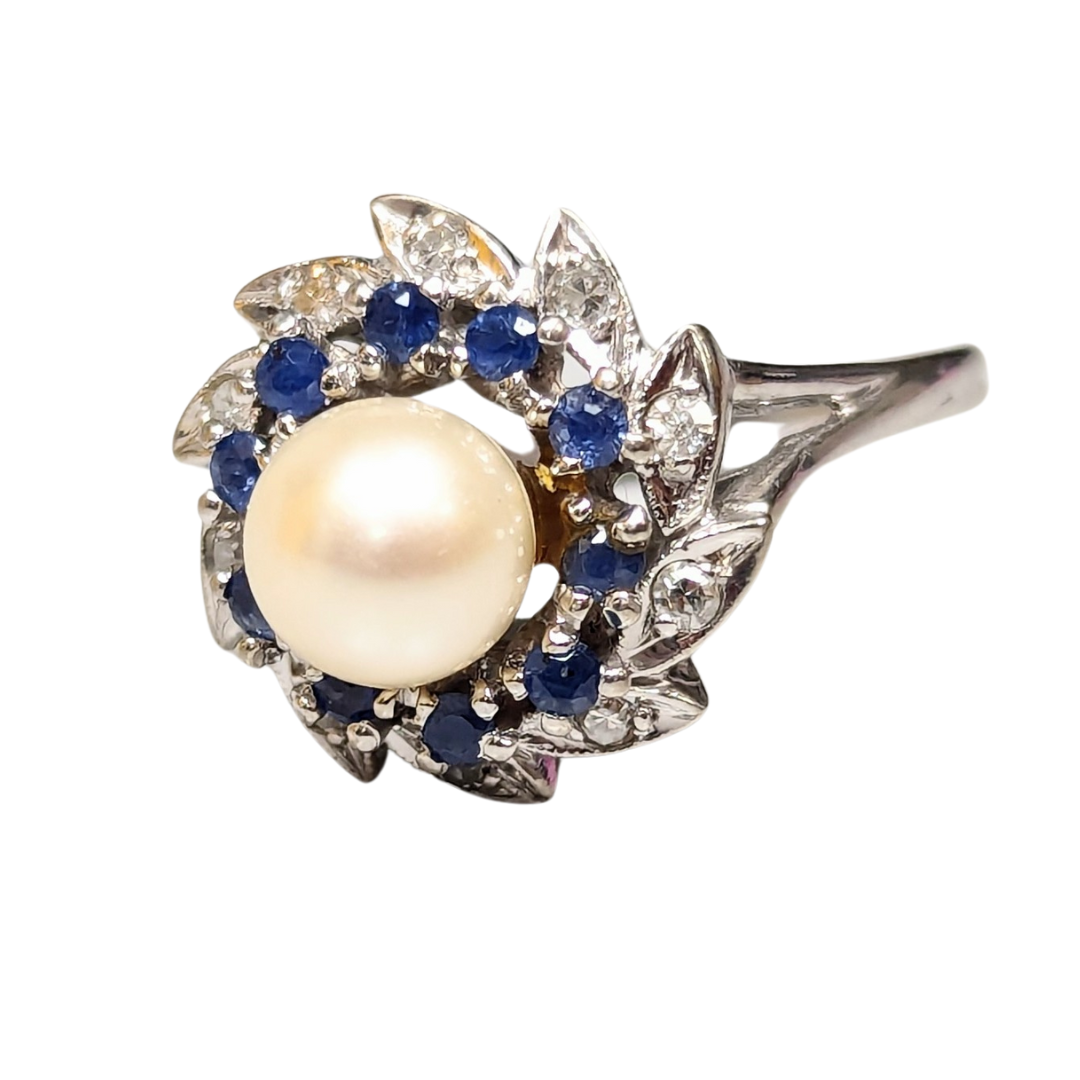 14K white gold cluster ring featuring a central cultured pearl surrounded by blue sapphires and diamonds.