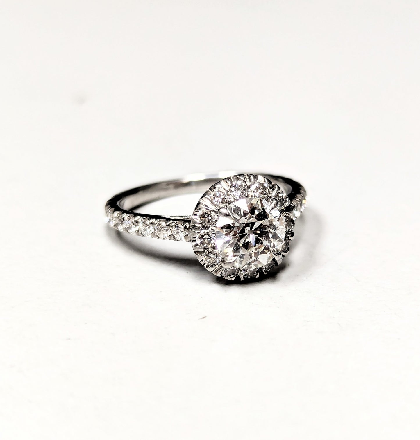Platinum halo engagement ring with a 1.01 carat Old European cut center diamond and diamond-accented band.