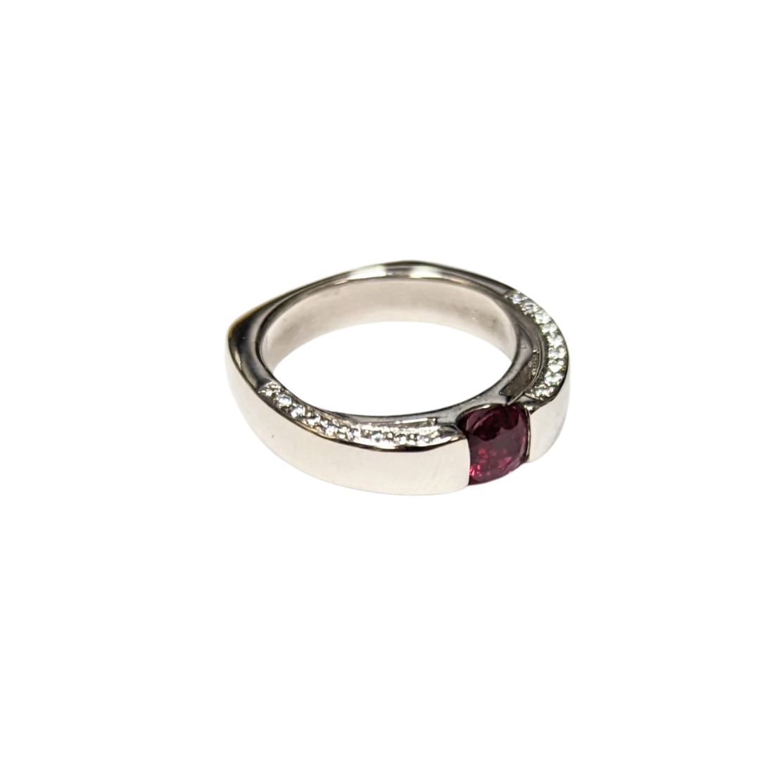 Platinum ring featuring a round ruby center stone accented by 40 brilliant-cut diamonds along the band.