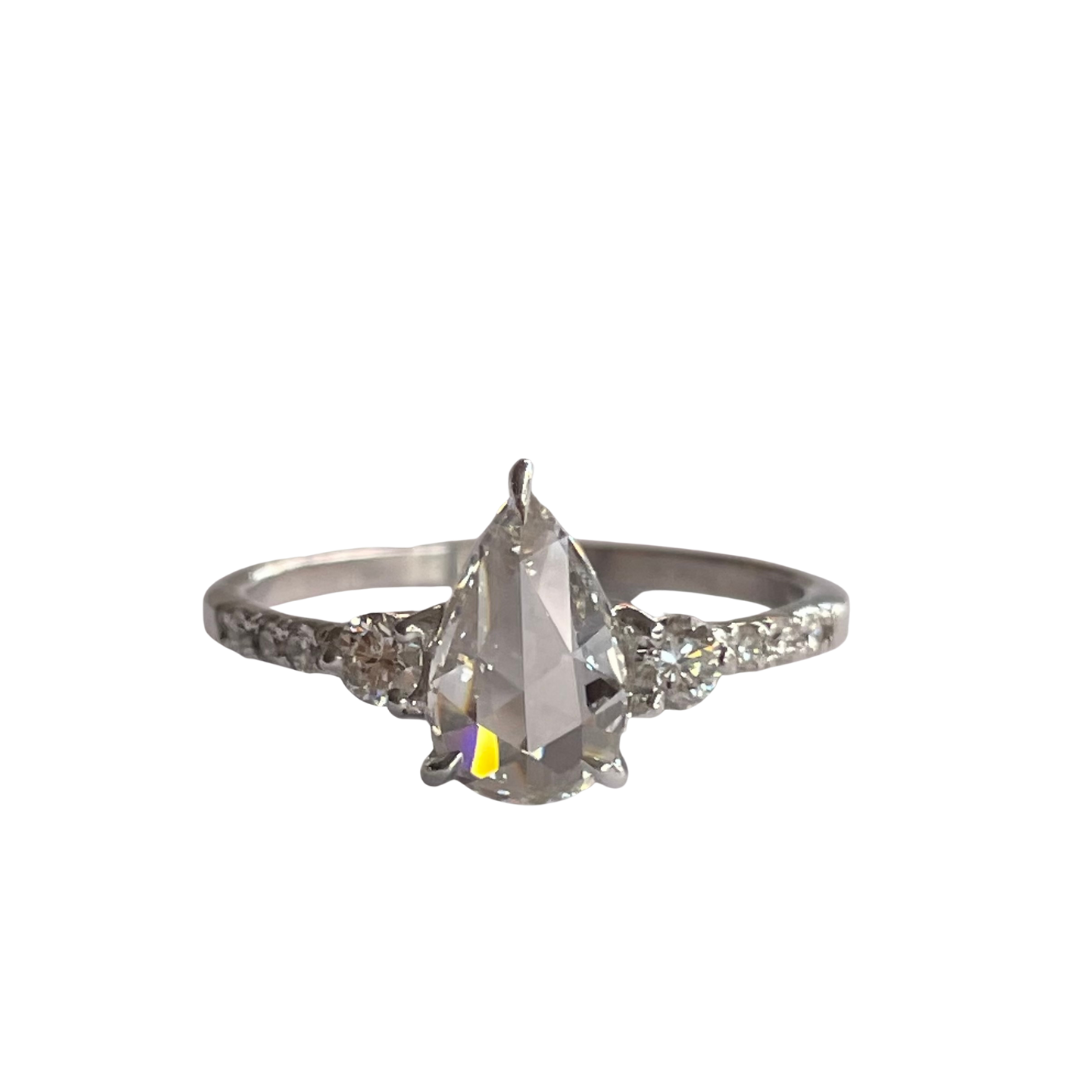 14K white gold engagement ring featuring a .63ct pear rose cut center diamond and round brilliant side stones.