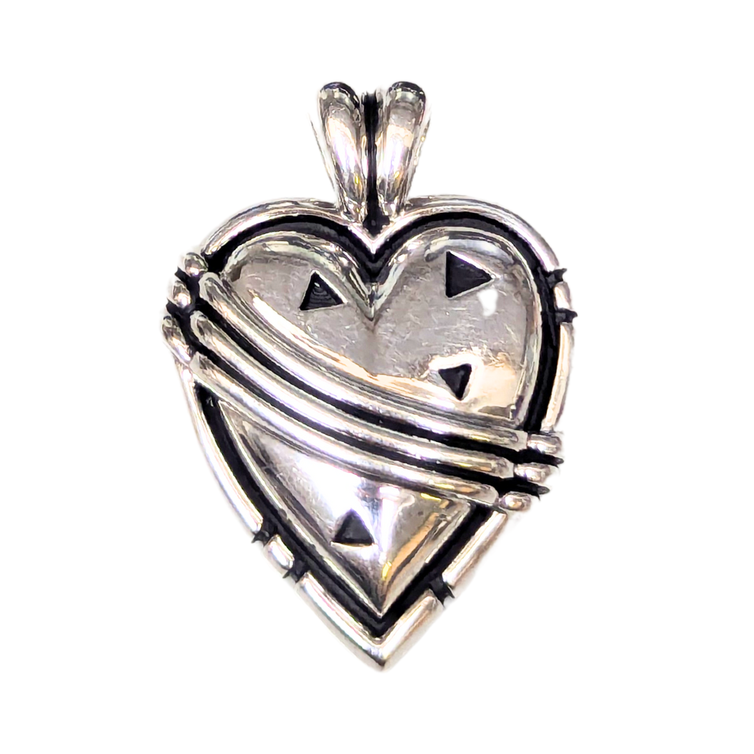 Sterling silver John Atencio heart pendant featuring polished metal, decorative layered bands, and cutout triangle accents.