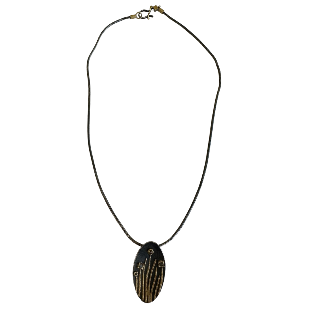 Todd Reed sterling silver and 18K gold oval pendant necklace with raw cube and rose cut brown diamonds on a 17-inch chain.