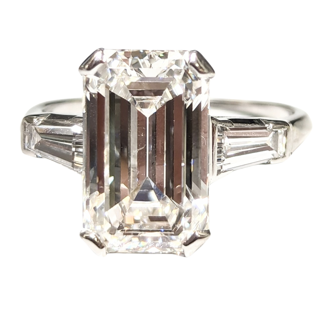 Vintage platinum three-stone ring with a 5.80 carat emerald cut diamond and tapered baguette side stones.